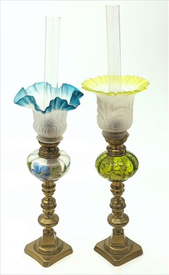 Lot 428 - Two glass and brass oil lamps, surmounted on a...