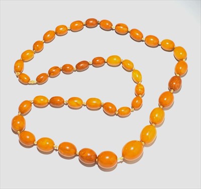 Lot 2676 - An amber necklace with graduated beads, the...