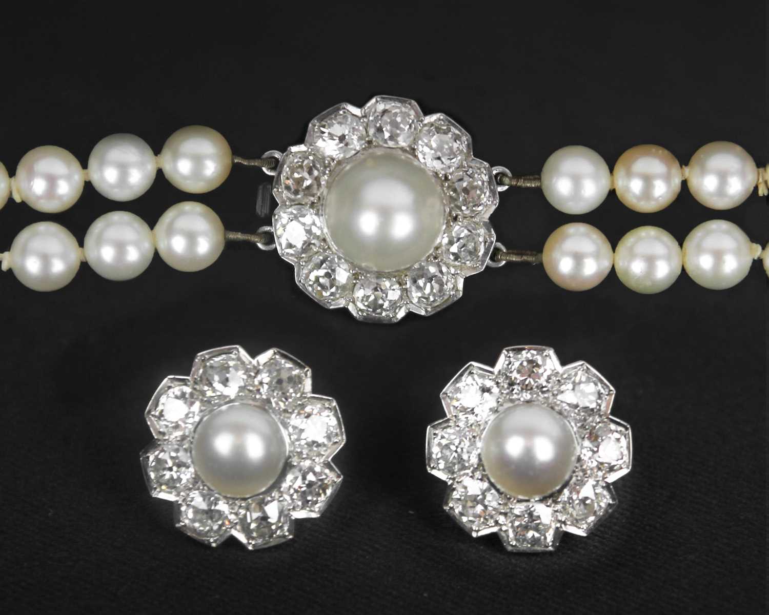 Lot 217 - An impressive early 20th century cultured pearl, diamond set, double-row necklace & earrings suite.