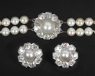 Lot 217 - An impressive early 20th century cultured pearl, diamond set, double-row necklace & earrings suite.