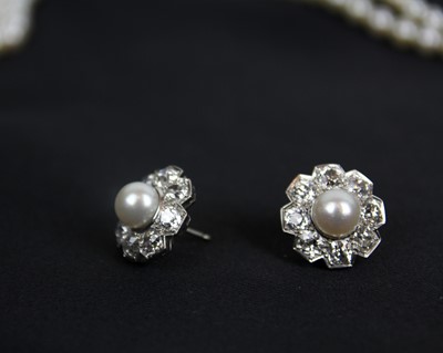 Lot 217 - An impressive early 20th century cultured pearl, diamond set, double-row necklace & earrings suite.
