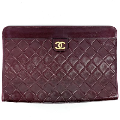 Lot 562 - A Chanel burgundy quilted lambs leather clutch bag.