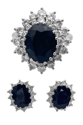 Lot 38 - An 18ct white gold diamond and sapphire cluster ring with a pair of matching earrings.