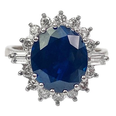 Lot 132 - An 18ct oval blue sapphire and diamond cluster ring.