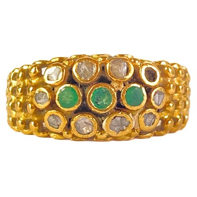 Lot 252 - A high purity gold (tests 18ct) diamond and emerald set band ring.