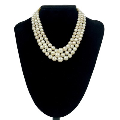 Lot 282 - A graduated cultured pearl three-strand necklace with emerald and split pearl rose gold clasp.