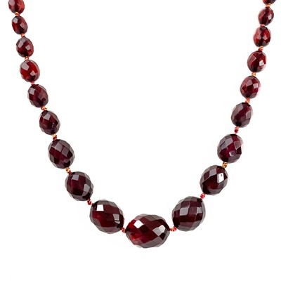 Lot 311 - A cherry amber bakelite faceted bead necklace.