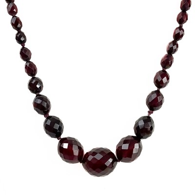 Lot 149 - A cherry amber bakelite faceted bead necklace.