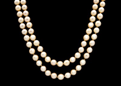 Lot 112 - A double row of uniform cultured pearls strung to a 14ct gold clasp set with pearls and emeralds.
