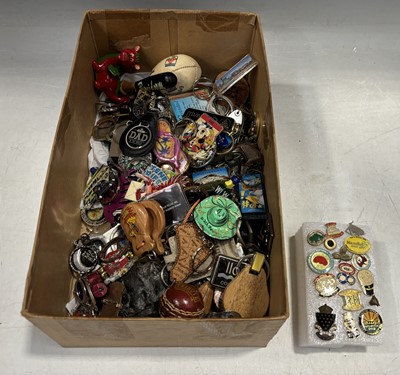 Lot 64 - A collection of keyrings and pin badges.