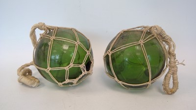Lot 259 - Two green glass fishing floats, approx 12cm wide.