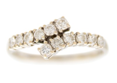 Lot 86 - A modern 18ct white gold diamond set twelve stone crossover style ring.