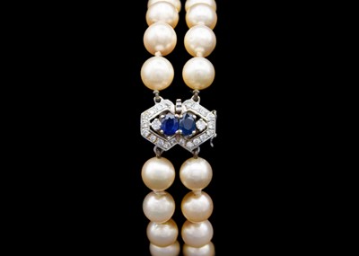 Lot 216 - A double-row cultured pearl bracelet with 18ct diamond and sapphire set clasp.
