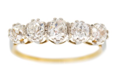 Lot 56 - An 18ct and platinum old mine cut diamond set five stone ring.