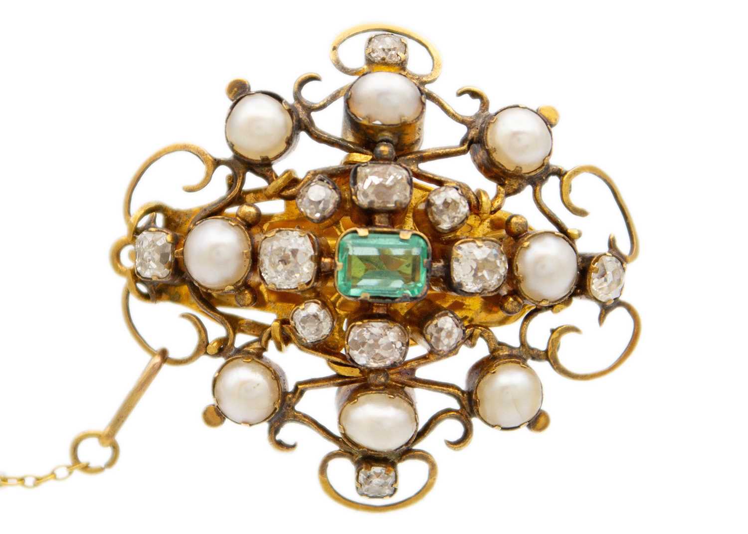 Lot 94 - An antique gold scroll brooch set with old mine cut diamonds, a central emerald and split pearls.