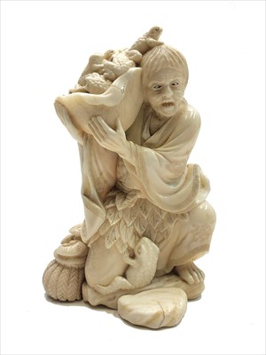 Lot 172 - A Japanese ivory okimono of a toad catcher,...