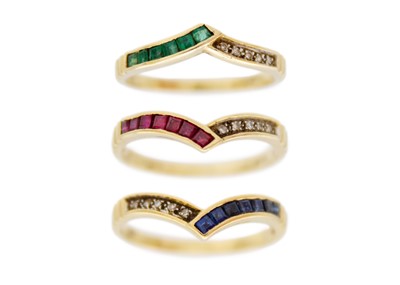 Lot 148 - A set of three diamond, emerald, ruby, and sapphire set wishbone rings, 18k set.