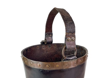 Lot 23 - A leather and copper bound riveted fire bucket.