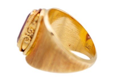 Lot 33 - An 18k gold synthetic colour-change sapphire band ring.