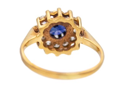 Lot 45 - A 9k gold synthetic sapphire and CZ halo ring.