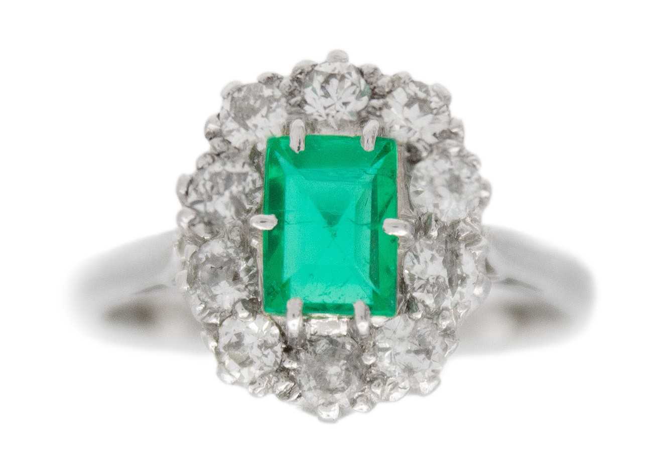 Lot 30 - An emerald and diamond set white gold cluster ring.