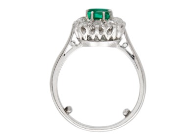 Lot 30 - An emerald and diamond set white gold cluster ring.