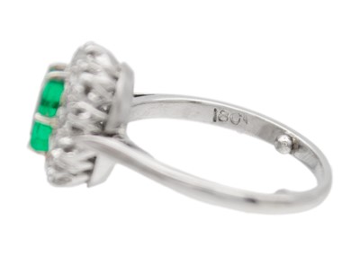 Lot 30 - An emerald and diamond set white gold cluster ring.