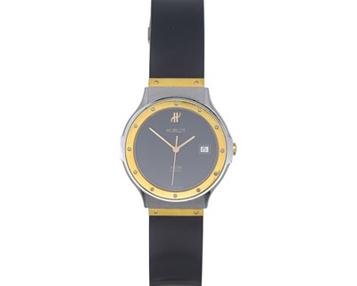 Lot 1098 - HUBLOT - An MDM gentleman's steel and gold mid-size quartz calendar wristwatch.
