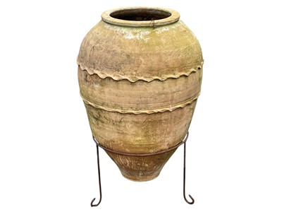 Lot 360 - A terracotta olive jar on a stand.