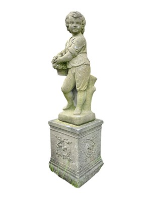 Lot 350 - A reconstituted stone statue of a boy with a basket of fruit.