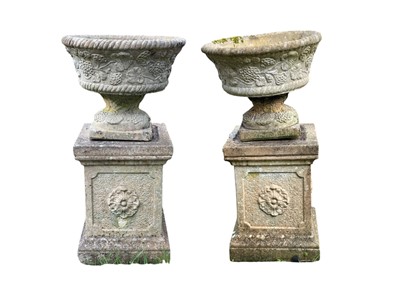 Lot 348 - A pair of reconstituted stone garden urns on separate plinths.