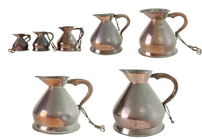 Lot 68 - A matched set of seven copper measure jugs.