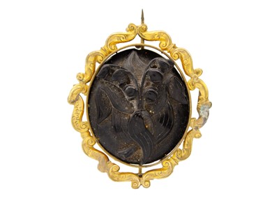 Lot 101 - A Victorian carved jet 'lily of the valley' gold mounted brooch.
