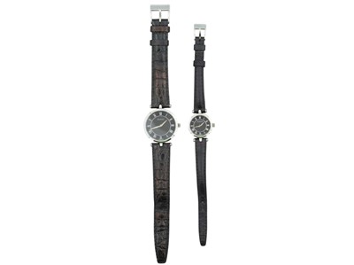 Lot 1093 - GUCCI - His and hers stainless steel and black enamel quartz wristwatches.