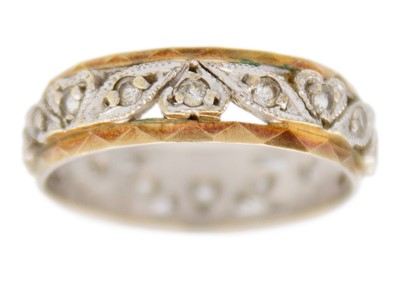 Lot 38 - A 9k bi-colour gold and synthetic white spinel set eternity band ring.
