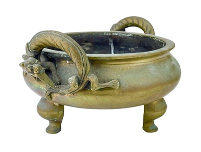 Lot 714 - A Chinese polished bronze tripod 'dragon' censer.