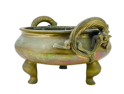 Lot 714 - A Chinese polished bronze tripod 'dragon' censer.
