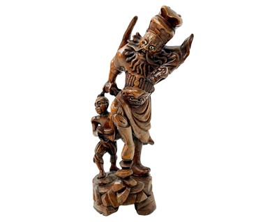 Lot 704 - A Chinese carved hardwood figure of a bearded warrior.
