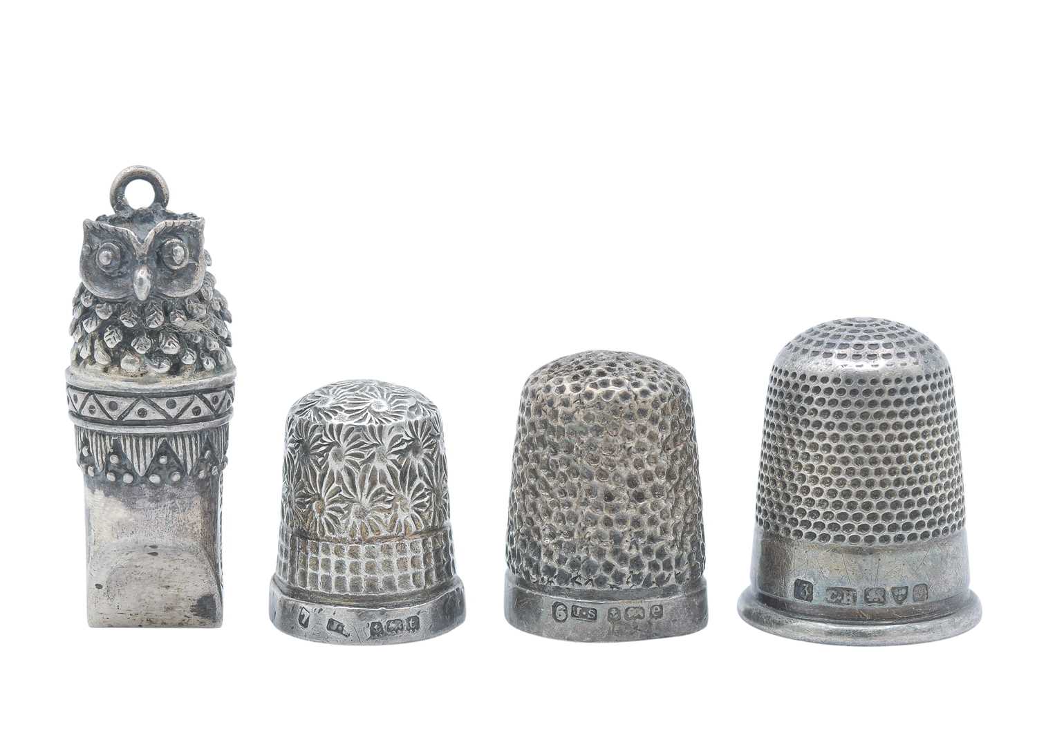 Lot 13 - A novelty owl whistle, together with three silver thimbles.