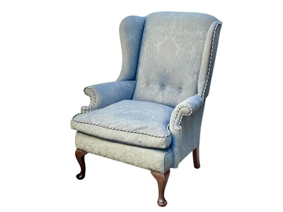 Lot 521 - A Georgian style walnut framed wing armchair.