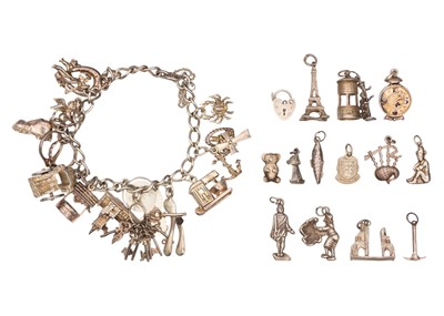 Lot 65 - A silver charm bracelet with a selection of other charms.