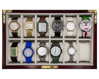 Lot 1034 - A collection of eleven quartz wristwatches, within a 12 section watch storage box.