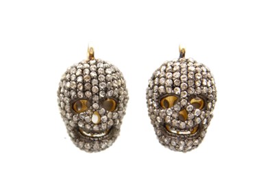 Lot 140 - A pair of silver gilt diamond-set skull pendants.