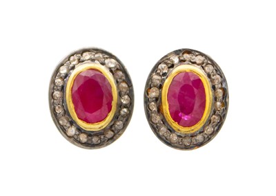 Lot 128 - A pair of gold-plated silver ruby and diamond halo set stud earrings.