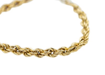 Lot 42 - A 9k gold rope bracelet with a safety chain.