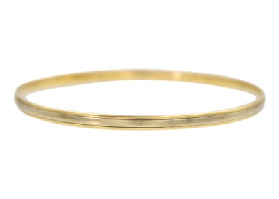 Lot 55 - A 9k two-tone gold bangle bracelet.