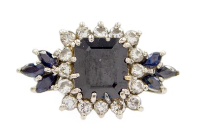 Lot 57 - A white gold sapphire and diamond set cluster dress ring.