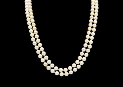 Lot 70 - A two-row pearl necklace fitted with 14k gold jadeite and diamond clasp.