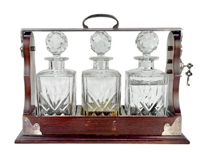 Lot 87 - A modern mahogany and silver plate three bottle tantalus.