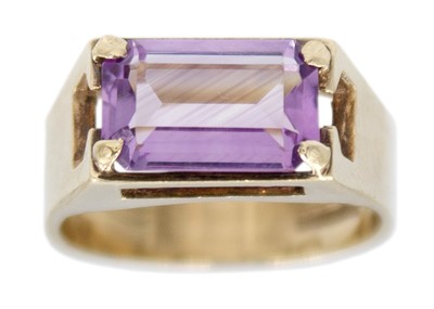 Lot 84 - A 9k gold amethyst set wide band ring.